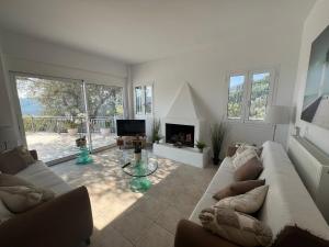 a living room with a couch and a fireplace at Villa Christina Nidri in Nydri