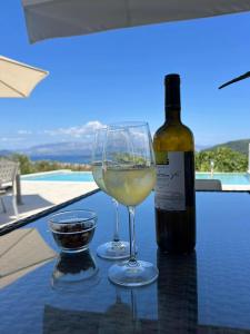 a bottle of wine and a wine glass on a table at Villa Christina Nidri in Nydri