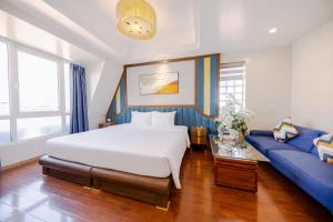 a bedroom with a large bed and a blue couch at Sky Charm Hanoi Hotel and Spa in Hanoi