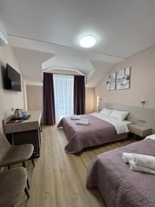a hotel room with two beds and a desk at Polyana Park House aparts in Polyana