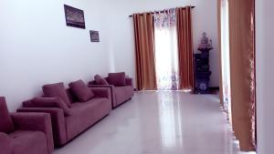 a living room with purple couches and a window at skymirror unawatuna in Unawatuna