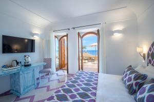 a hotel room with a bed and a view of the ocean at Hotel Il Gabbiano in Positano