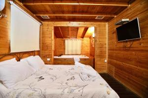 a bedroom with a bed in a wooden room at נופים בלבן - בקתה עם בריכה פרטית ואמבט ספא in Moshav Ramot +32 photos