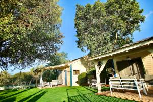 a yard with chairs and a house at נופים בלבן - בקתה עם בריכה פרטית ואמבט ספא in Moshav Ramot