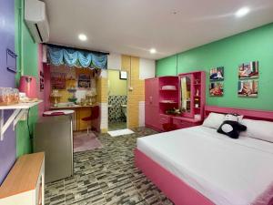 a bedroom with a bed and green and pink at OYO 75539 Phanthida Resort and Cafe in Hua Hin
