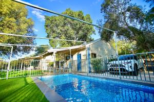 a house with a fence and a swimming pool at נופים בלבן - בקתה עם בריכה פרטית ואמבט ספא in Moshav Ramot