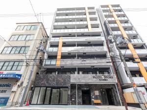 an apartment building with a hotel sign in front of it at Hotel Story Namba by Tabist in Osaka