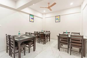 a dining room with tables and chairs and a ceiling fan at Treebo Adithi Comforts Inn And Suites in Mysore