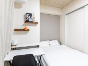 a bedroom with a white bed and a desk at Hotel Story Namba by Tabist in Osaka