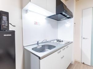 a kitchen with a sink and a microwave at Hotel Story Namba by Tabist in Osaka