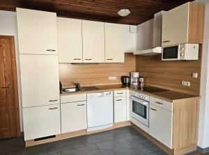 a kitchen with white cabinets and a sink at Biohof Besenbäck in Rappottenstein