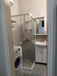 a bathroom with a washing machine and a sink at Bonaca in Igalo