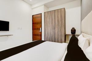 a bedroom with a white bed and a television at Townhouse Hotel Sec- 54 Golf Course Road in Gurgaon