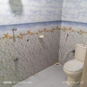 a bathroom with a shower with a toilet at Cattleya Guest House in Tissamaharama