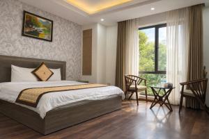 a bedroom with a bed and a window and a table at Phương Anh Villa 1 in Bắc Ninh