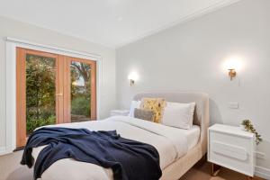 a white bedroom with a bed and a window at Spring Hill Holiday Units - Queenscliff in Queenscliff +20 photos