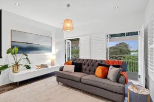 a living room with a couch and a large window at Spring Hill Holiday Units - Queenscliff in Queenscliff