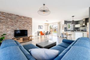 a living room with a blue couch and a brick wall at Nouveau ! Bulle d'air - Maison avec piscine in Bouaye