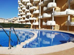 a swimming pool in front of a building at Les Motes Solo Familias Serviplaya!!! in Playa de Xeraco