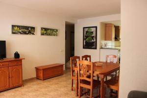 a kitchen and dining room with a table and chairs at Delfines II Solo Familias Serviplaya in Playa de Xeraco