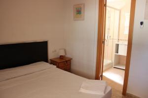 a bedroom with a bed and a night stand with a window at Delfines II Solo Familias Serviplaya in Playa de Xeraco +29 photos