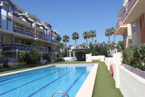 a swimming pool in front of a building at Delfines II Solo Familias Serviplaya in Playa de Xeraco