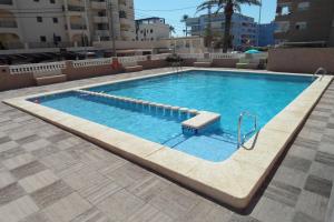 a large swimming pool with a bench in a building at Wimpy Solo Familias Serviplaya in Playa de Xeraco