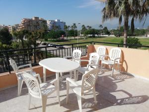 a group of white chairs and a table on a balcony at Oasis Solo Familias Serviplaya in Playa de Xeraco