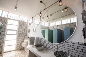 a bathroom with a mirror and a sink at Memmoth Cafe & Hostel in Lampang in Lampang +48 photos