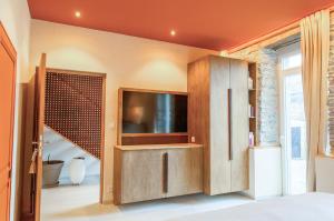 a living room with a television and a staircase at La Maison Brevan in Châteaulin