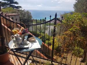 a table on a balcony with a view of the ocean at La Camera Tra Gli Ulivi Dream Finale in Finale Ligure