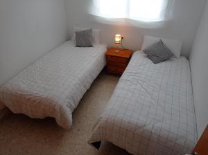 two beds sitting next to each other in a room at Palmeras III Solo Familias Serviplaya!!! in Gandía +53 photos