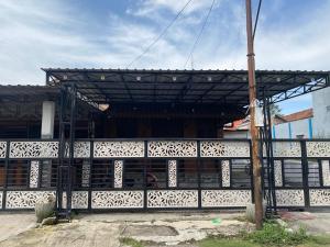 a building with a wooden structure with a fence at Guest House Brahu Syariah in Trowulan +8 photos