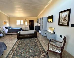 a bedroom with a bed and a living room with a couch at Waterval Karoo Guest Farm in Laingsburg