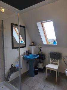 a bathroom with a blue sink and a shower at Watt in Karolinenkoog