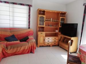 a living room with a bed and a tv at Les Motes Solo Familias Serviplaya!!! in Playa de Xeraco