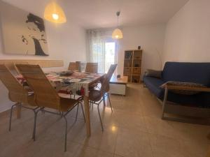 a living room with a table and chairs and a couch at Delfines III Solo Familias Serviplaya in Playa de Xeraco