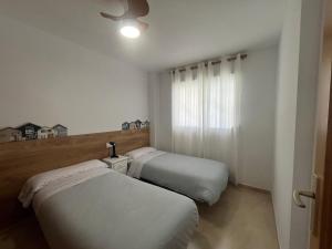 two beds in a small room with white walls at Parquemar III-IV Solo Familias!!! Serviplaya in Playa de Xeraco +259 photos