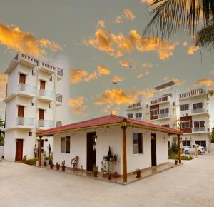 a building in front of some white buildings at Gold Mountain Wellness Resort in Tiruvannāmalai