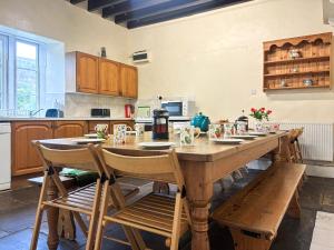 a large kitchen with a wooden table and chairs at High Rylands in Arncliffe