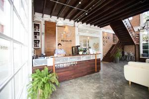 a woman standing behind a counter in a building at Memmoth Cafe & Hostel in Lampang in Lampang