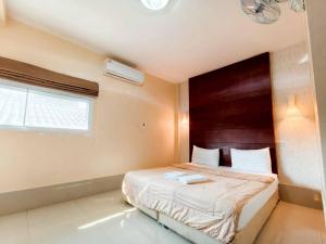 a bedroom with a bed and a window in it at Veerakit Grand Hotel Udon Thani in Udon Thani
