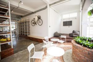 a room with a table and chairs and a bike on the wall at Memmoth Cafe & Hostel in Lampang in Lampang
