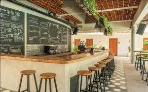 a bar with stools and a menu on a wall at Lay Day Hostel Uluwatu in Uluwatu