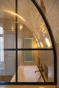 a bathroom with a bath tub and a window at Palazzo Zimara - The D'Angelo Family Collection in Lecce