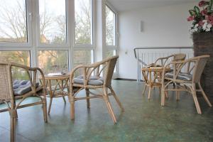 a room with four chairs and a table and windows at Am Langenwerder Whg 4 in Gollwitz