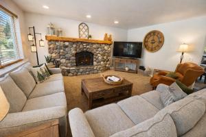 a living room with couches and a stone fireplace at All Seasons Getaway in Leavenworth