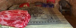 a bedroom with a bed with a patterned blanket on it at Anurag singh homestay in Gaura Umarni