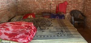 a bed in a room with a brick wall at Anurag singh homestay in Gaura Umarni