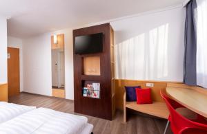 ein Hotelzimmer mit Bett, Schreibtisch und Stuhl in der Unterkunft ibis Kassel Melsungen in Melsungen